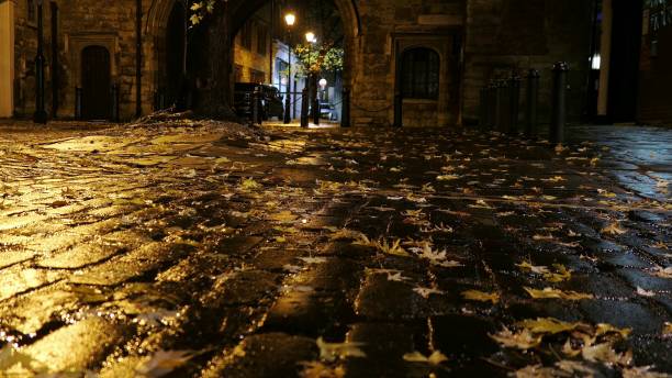 istock Man Walking Empty Cobbled Street in London at Night 1667614483