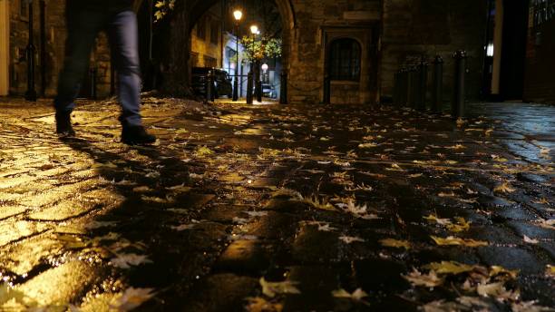 夜のロンドンの空の石畳の通りを歩く男 - single lane road stone night street ストックフォトと画像