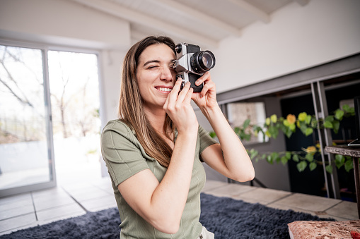 Mid adult woman using a digital camera at home