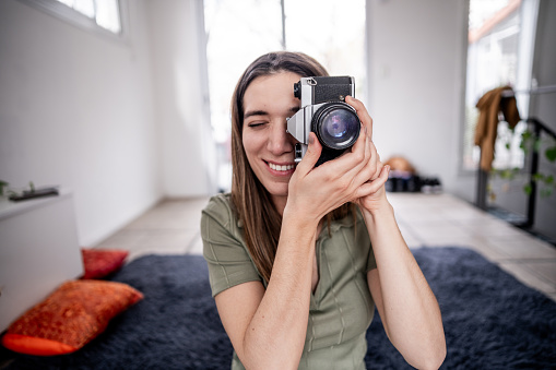 Mid adult woman using a digital camera at home