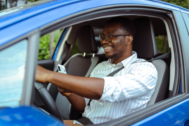 istock appy young African-American man driving and using smart phone 1667636306