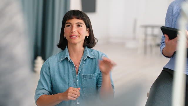 Hispanic businesswoman talking and smiling during meeting at startup office