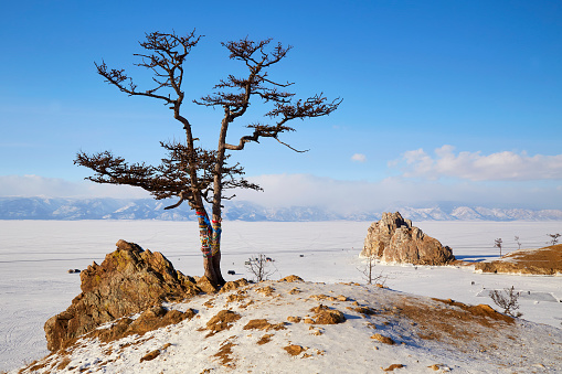 View of Cape Burhan or Shamanka rock on Olkhon island in winter. Frozen Lake Baikal, snow on the surface of the ice.