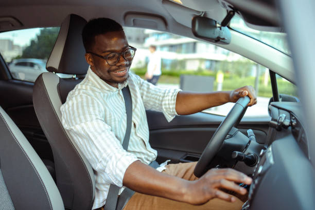 istock Cheerful male driver changing radio stations in car 1667647365