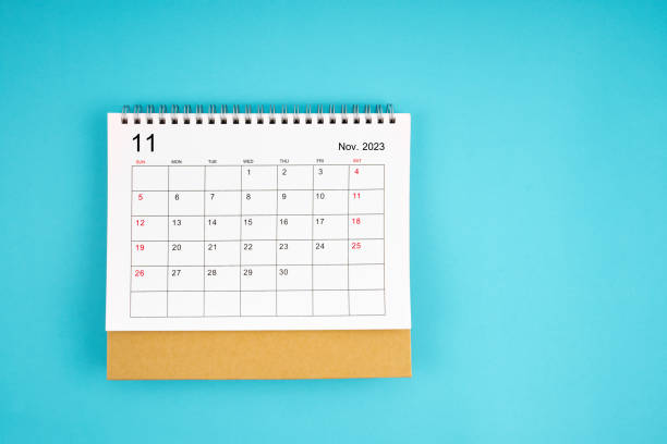 el calendario de escritorio mensual de noviembre de 2023 para el año 2023 sobre fondo de color amarillo. - calendar time deadline autumn fotografías e imágenes de stock
