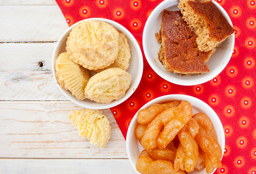 Traditional South African sweet food on rustic wood with traditional printed cloth. Milk tart, koek sisters and malva pudding