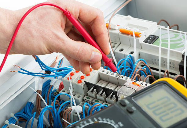 Hand of an electrician Hand of an electrician with multimeter probe at an electrical switchgear cabinet multimeter stock pictures, royalty-free photos & images