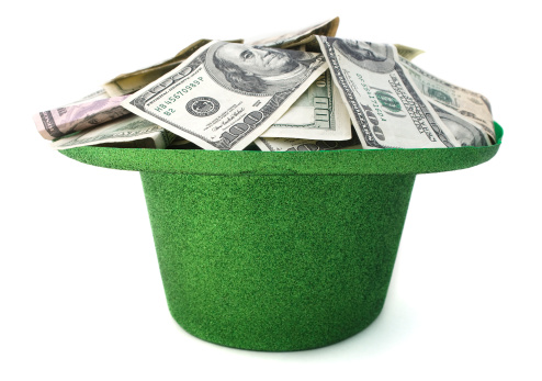 St. Patrick's Day hat filled with cash on a white background.