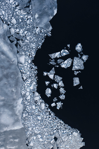 Aerial view of an ice surface breaking up and melting.