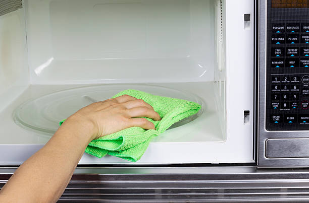 Cleaning inside of Microwave Oven stock photo