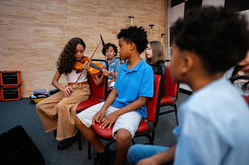 Girl playing violin in a music class