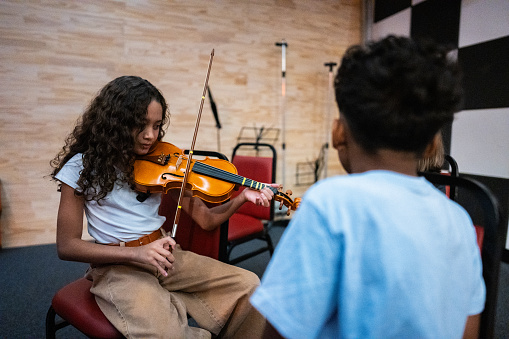 Girl playing violin during a music class