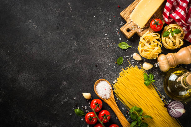 istock Pasta ingredients on black background.  Top view with copy space. 1667682821