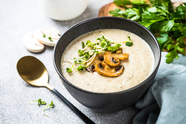 istock Mushroom Soup in craft bowl on light stone table. 1667685560