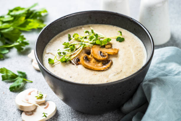 istock Mushroom Soup in craft bowl on light stone table. 1667686691