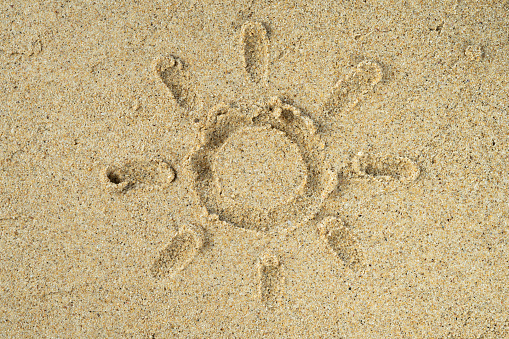 Beach sand texture with sun drawn