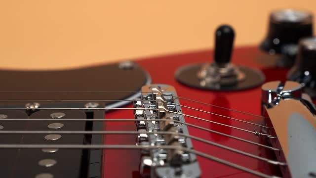 Six-string electric guitar. The camera moves to the rhythm of the guitar.