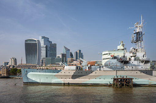 London, UK: HMS Belfast, a Royal Navy warship that was active in World War Two. She is now a museum ship on the River Thames in London. The City of London is behind.