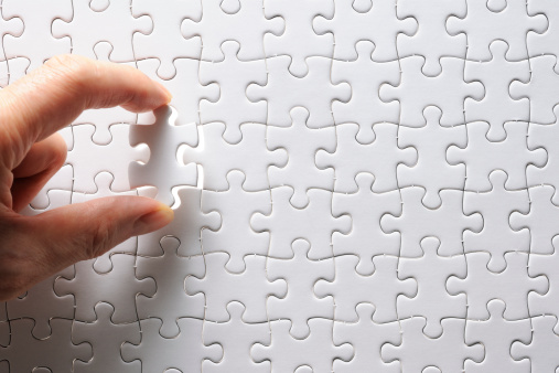 Holding a blank final piece of the jigsaw with light from behind.