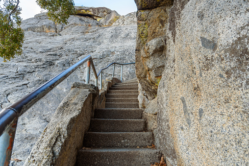 Deserted narrow stairway with metal handrails leading up a rocky mountain peak. Moro Rock, Sequoia National Park, CA, USA.