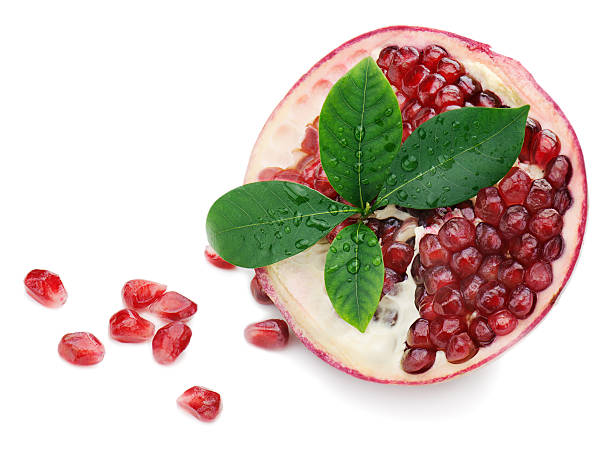 istock Pomegranate fruit with green leaves isolated on white background 166780479