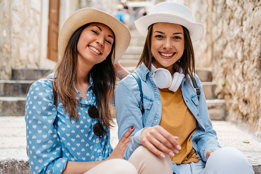 Portrait of two female friends sitting on the steps in Dubrovnik in Croatia.