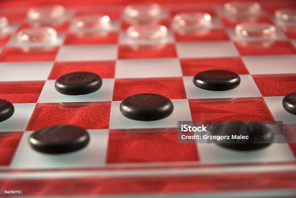 Checkboard Glass checkers, ready to play on red tablecloth. Shallow DOF Backgrounds Stock Photo