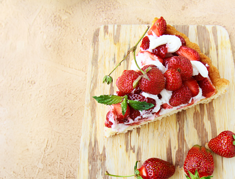 piece of pie with strawberries on a wooden board