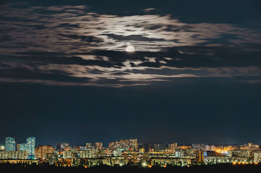 Empty dramatic dark blue night sky with full moon and storm clouds