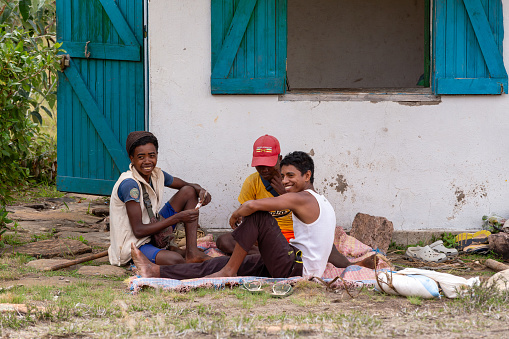 Andringitra, Madagascar - November 16th, 2022: Young Malagasy men resting in the shade of a house and playing cards.