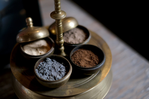 Close-up shot of variation beauty spa powder for scrub massaging inside a brass bowl.