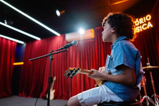 istock Boy singing and playing a guitar (cavaco) in a music contest 1667840182