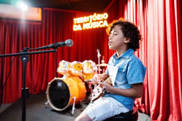 istock Boy singing and playing a guitar (cavaco) in a music contest 1667840469