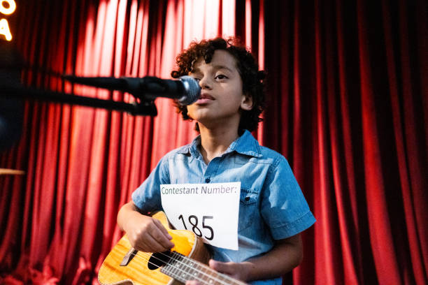 istock Boy singing and playing a guitar (cavaco) in a music contest 1667841013