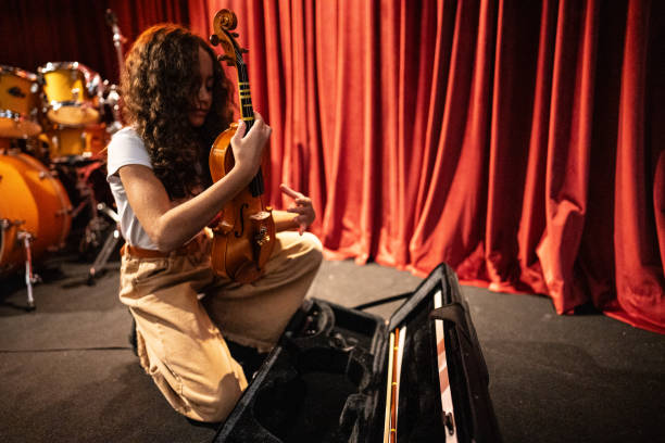 девушка готовит свою скрипку к музыкальному конкурсу - latin american and hispanic ethnicity child violin music стоковые фото и изображения