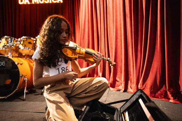 istock Girl preparing her violin in a music contest 1667842100