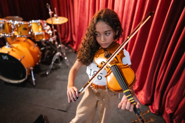 istock Girl playing violin in a music contest 1667842623