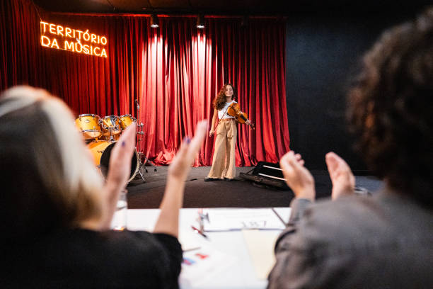 girl playing violin in a music contest - jury entertainment foto e immagini stock