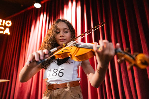 istock Girl playing violin in a music contest 1667842646