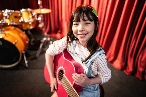 Portrait of a girl playing guitar in a music contest