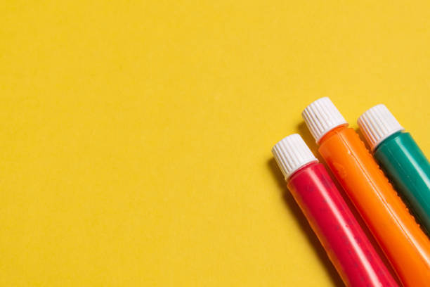 istock THREE TUBES OF SCHOOL PAINT, ON A YELLOW BACKGROUND. 1667849740