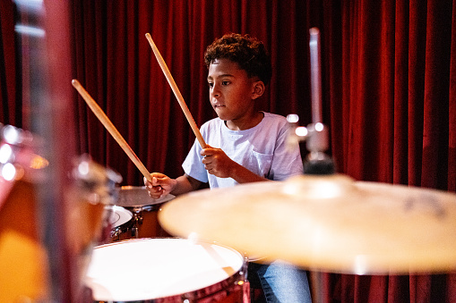 Boy playing drums in a music school
