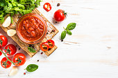 Tomato sauce with herbs and spices at white background.