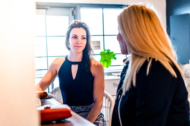 istock Two beautiful millennial age women sit at a bar or restaurant having a conversation 1667897915