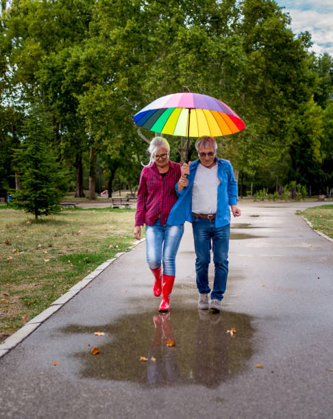 istock Couple under umbrella in autumn park 1667898743