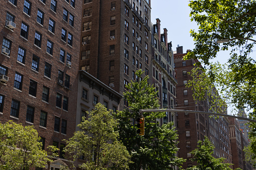 A row of beautiful old brick residential buildings and skyscrapers along Fifth Avenue in Greenwich Village of New York City