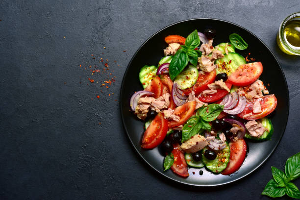 istock Tuna salad with cucumber and tomato. Top view with copy space. 1667950045