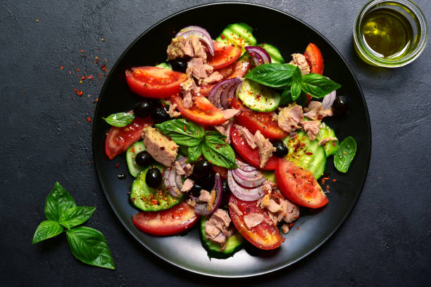 istock Tuna salad with cucumber and tomato. Top view with copy space. 1667950111