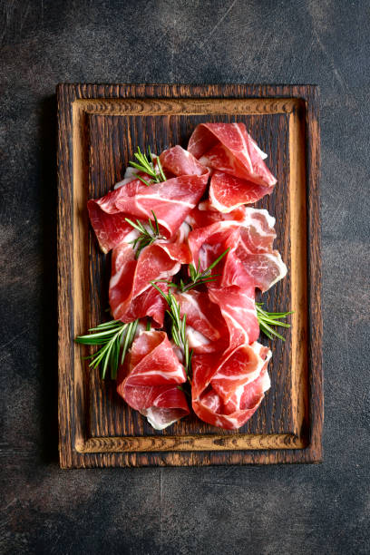 istock Slices of prosciutto di parma or jamon serrano (iberico) . Top view with copy space. 1667963919