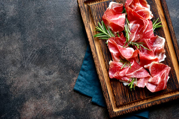 istock Slices of prosciutto di parma or jamon serrano (iberico) . Top view with copy space. 1667963931